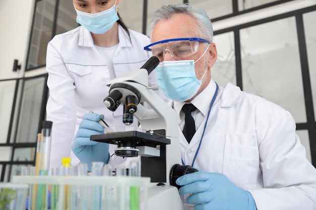 Close up scientists working with microscope