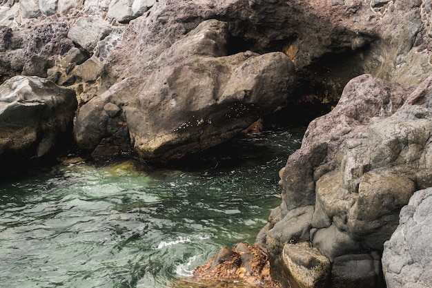 Close-up sea touching rocky shore