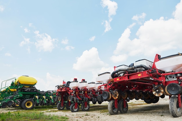 Close up of seeder attached to tractor in field.