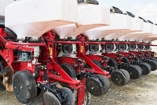 Close up of seeder attached to tractor in field.