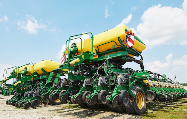 Close up of seeder attached to tractor in field.