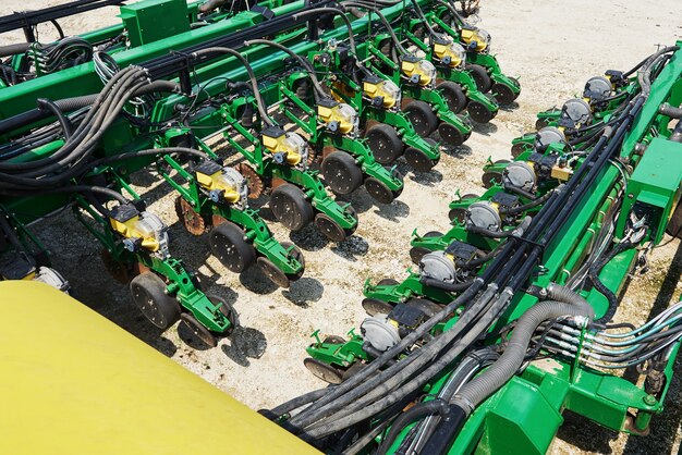 Close up of seeder attached to tractor in field.