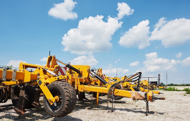 Close up of seeder attached to tractor in field.