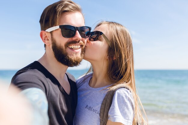 Close-up self-portrait of cute couple near sea