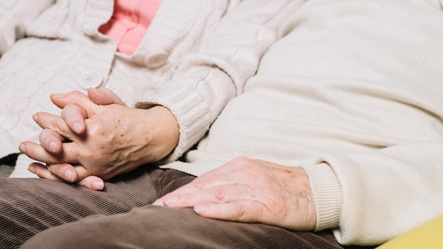 Close up of senior couple holding hands