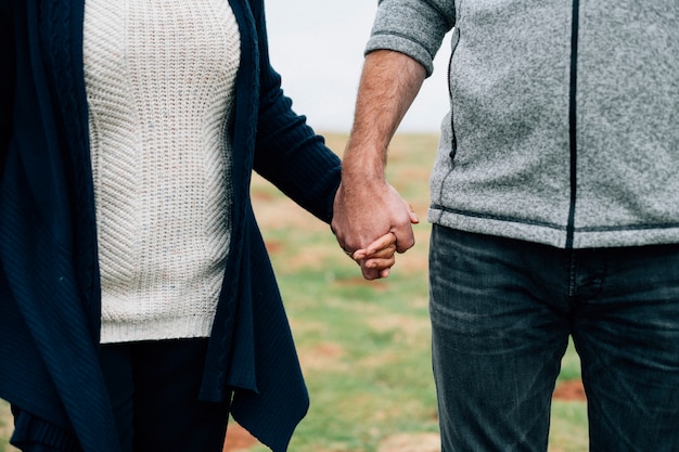 Close up of senior couple holding hands