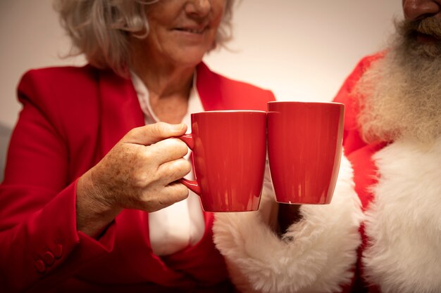 Close-up senior couple toasting with mugs