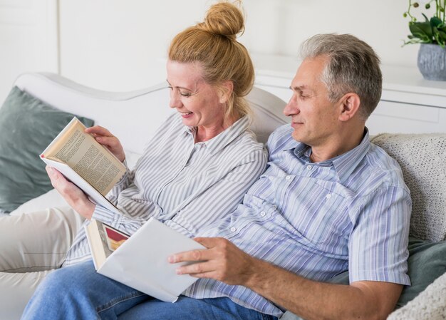 Close-up senior couple with book on a couch
