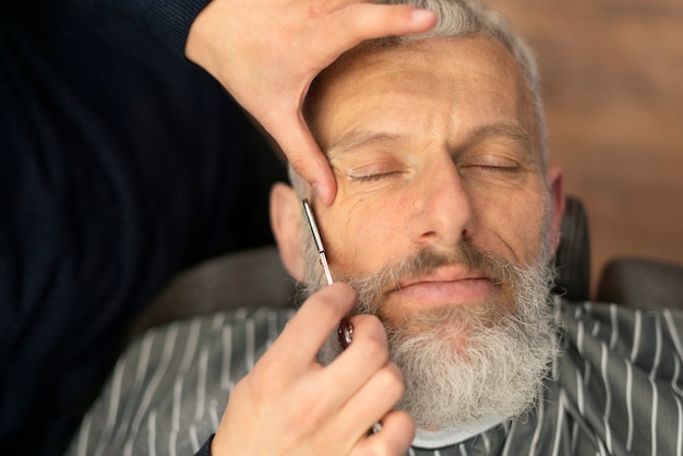 Free photo close up senior man getting groomed