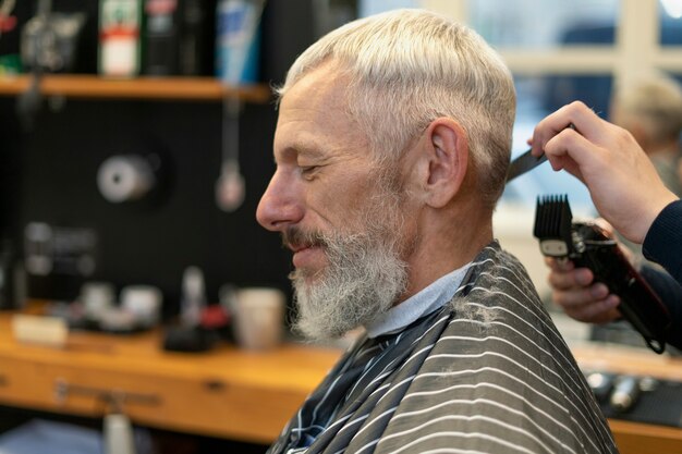 Free photo close up senior man getting haircut