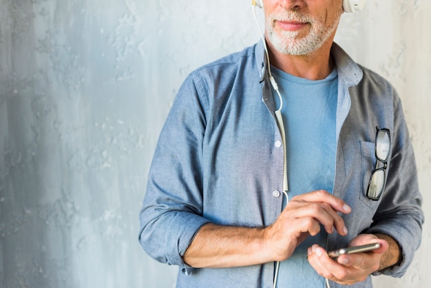 Primo piano del cellulare della tenuta dell'uomo senior