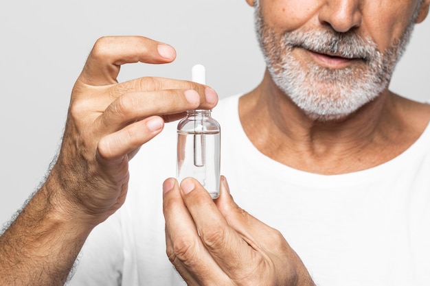 Free photo close-up senior man holding serum