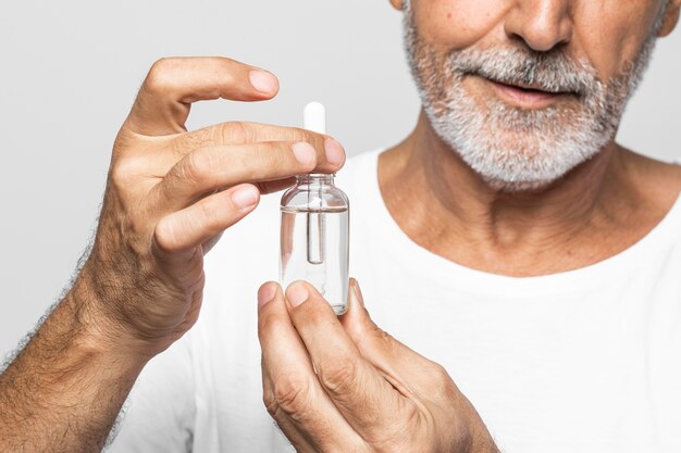 Close-up senior man holding serum