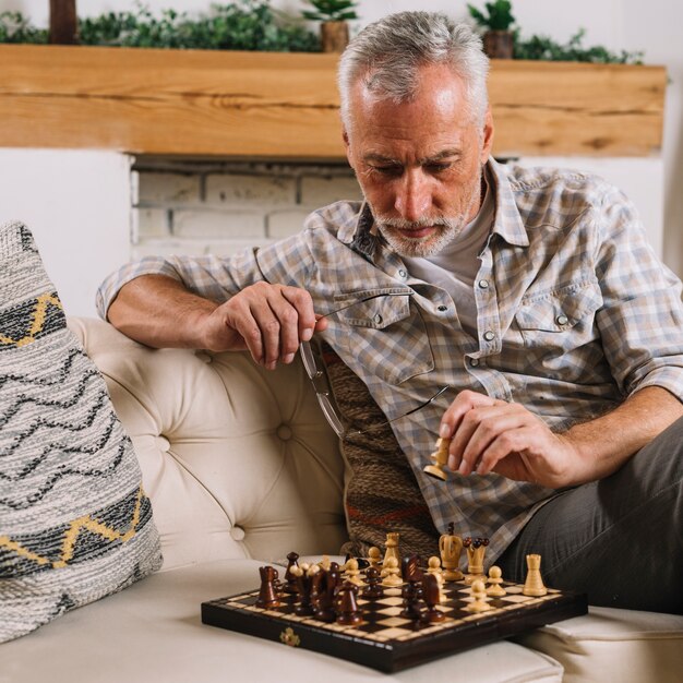 Close-up of senior man playing chess