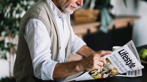 close-up of senior man reading newspaper