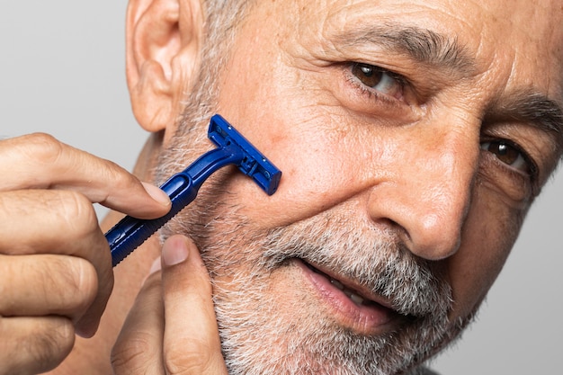 Close-up senior man shaving