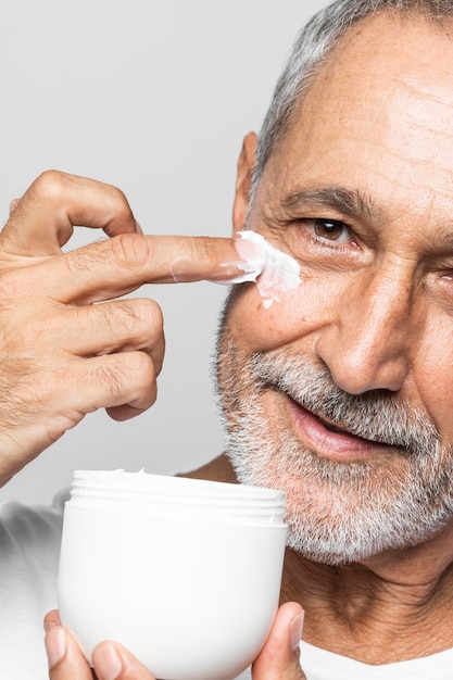 Free photo close-up senior man using cream