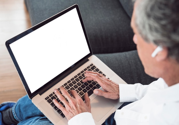 Close-up of senior man using laptop with white screen