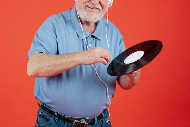 Foto gratuita uomo senior del primo piano con il record di musica