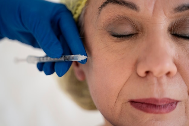 Free photo close up senior woman getting injection