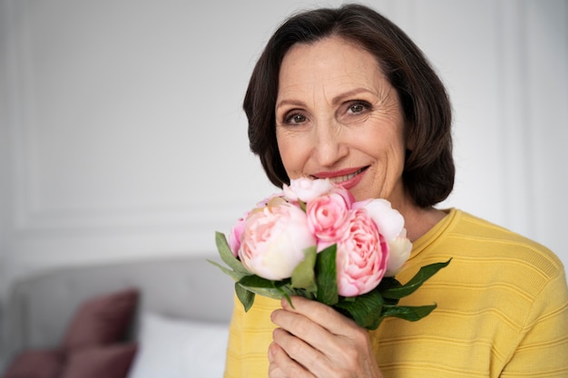 Close up senior woman holding flowers