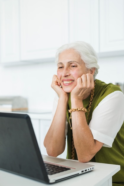 Foto gratuita primo piano della donna maggiore che esamina computer portatile