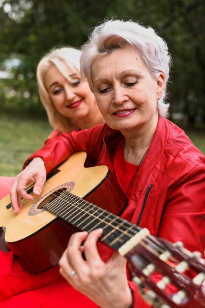 Close-up senior woman playing guitar