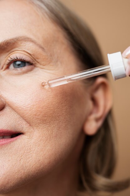 Close up senior woman using serum