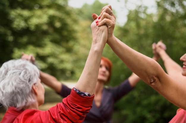 Close-up senior women holding hands