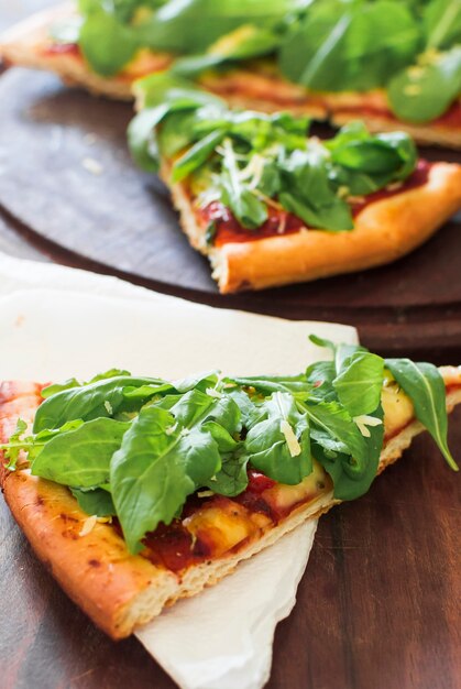 Close-up of served pizza slice on tissue paper