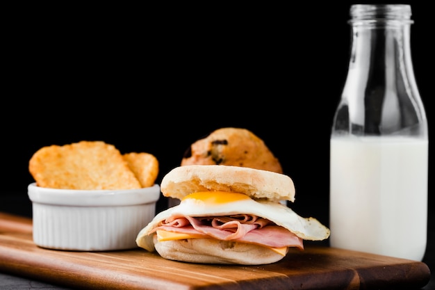 Close-up set benedict egg sandwich next to milk bottle