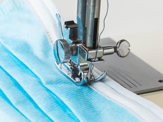 Close-up of sewing machine and medical mask