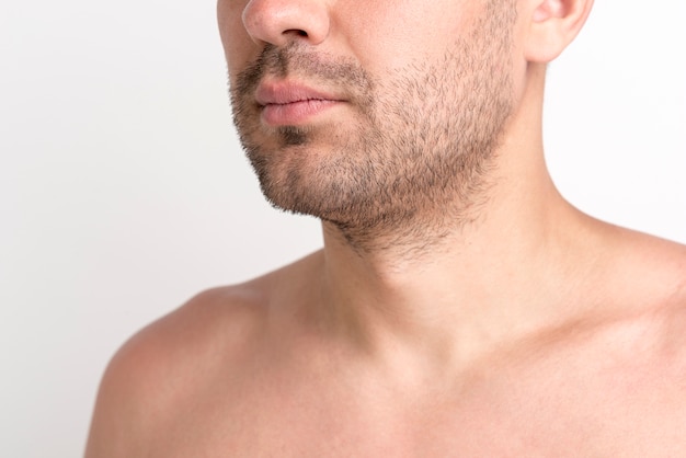 Close-up of shirtless stubble man against white background