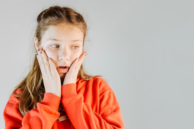 Close-up of a shocked girl on grey background