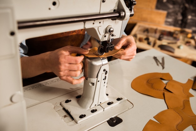 Close up of a shoemaker using sewing machine