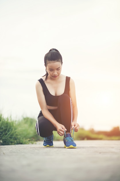 Close up shoes Female runner tying her shoes for a jogging exercise