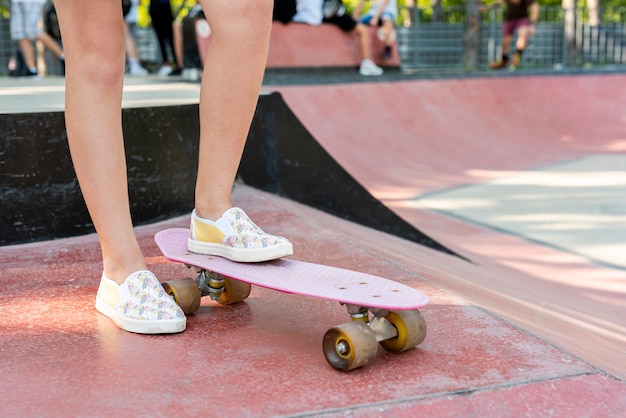 Close-up of shoes on pink skateboard