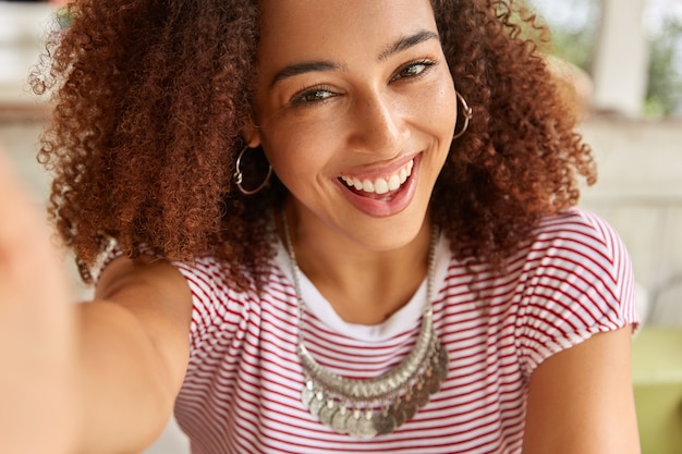 Free photo close up shot of attractive dark skinned girl looks joyfully