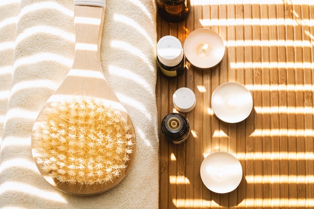 Close-up shot of bathing brush with essential oils and candles. SPA concept.