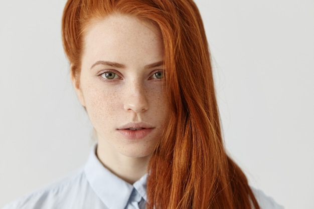 Free photo close up shot of beautiful redhead girl with perfect clean skin with freckles and long hairstyle