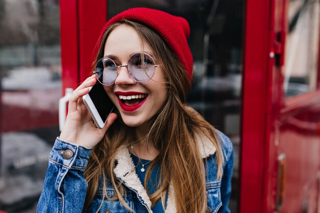 Close-up shot of beautiful woman in casual glasses talking on phone.
