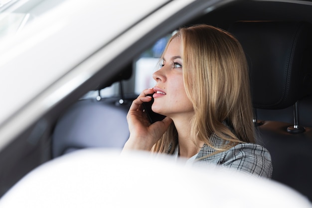 Colpo del primo piano di una donna bionda che parla al telefono