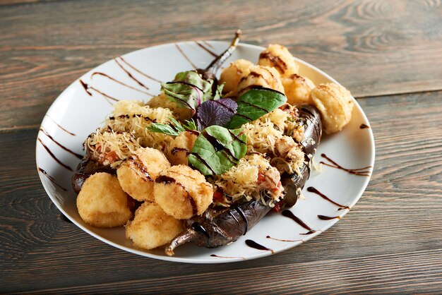 Close up shot of delicious fried cheese balls served with eggplant and basil on a wooden table cafe restaurant meal dinner lunch hungry appetite tasty nutrition concept.