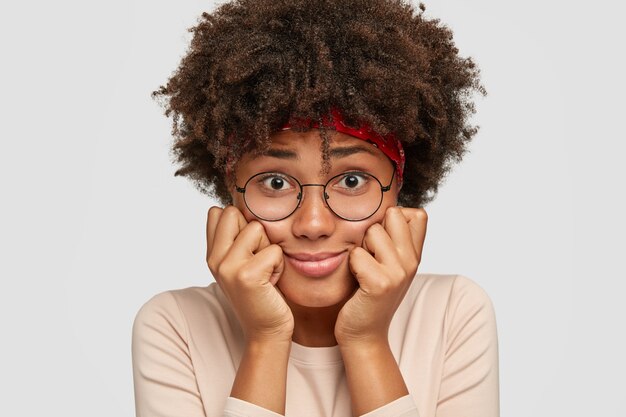 Close up shot of embarrassed black lady has surprised dejected facial expression