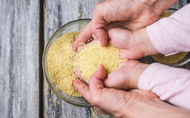 Close up shot of hands put in a fresh whole amarath grain bowl