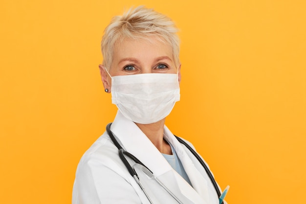 Крупным планом снимок женщины-эпидемиолога среднего возраста, расследующей закономерности, причины и травмы инфекционного заболевания, в медицинской маске