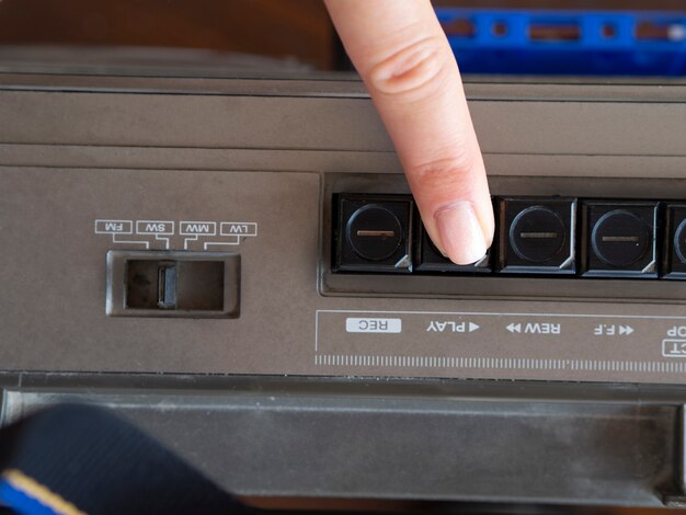 Close-up shot person pushing music player's play button