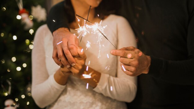 Close-up shot senior couple holding fireworks