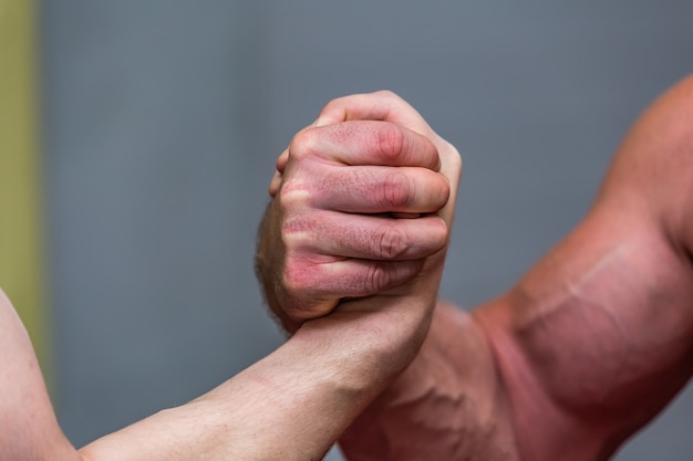 Primo piano dei muscoli di un uomo forte durante un combattimento di braccio di ferro