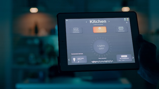 Close up shot of tablet with active smart home application holded by man